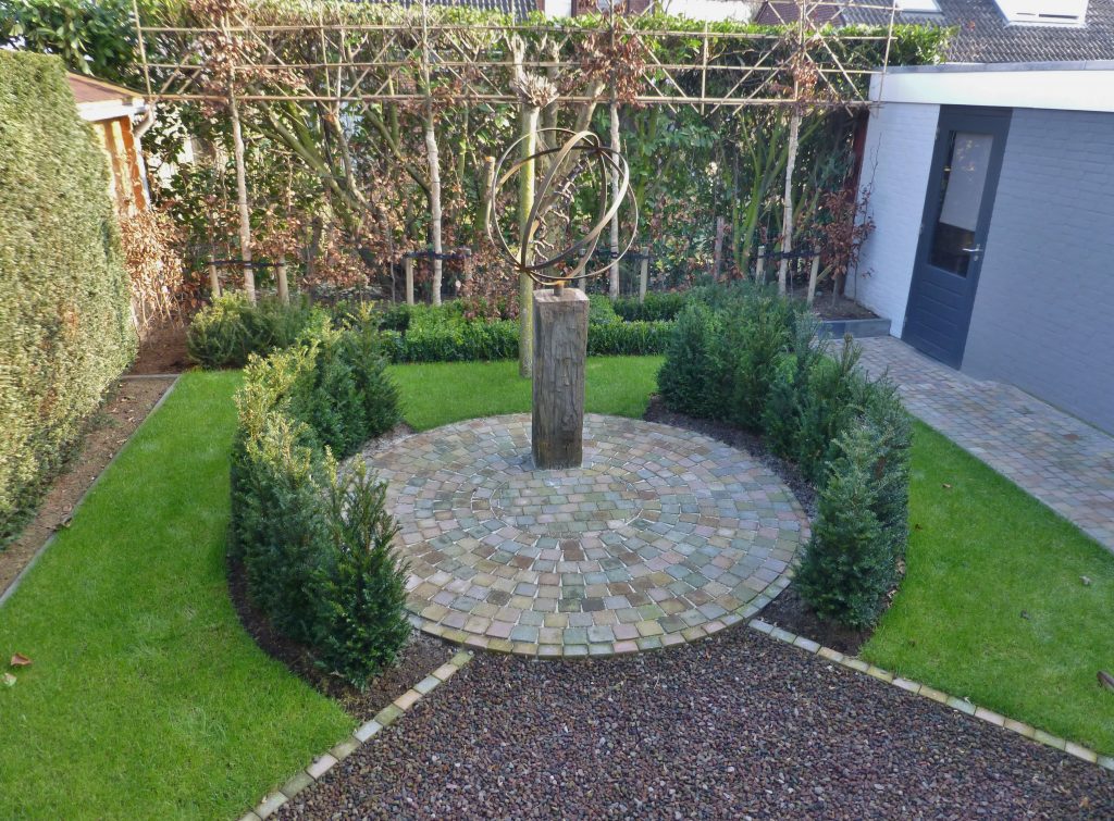 Betegelde voortuin met ruimte voor plantenbakken
